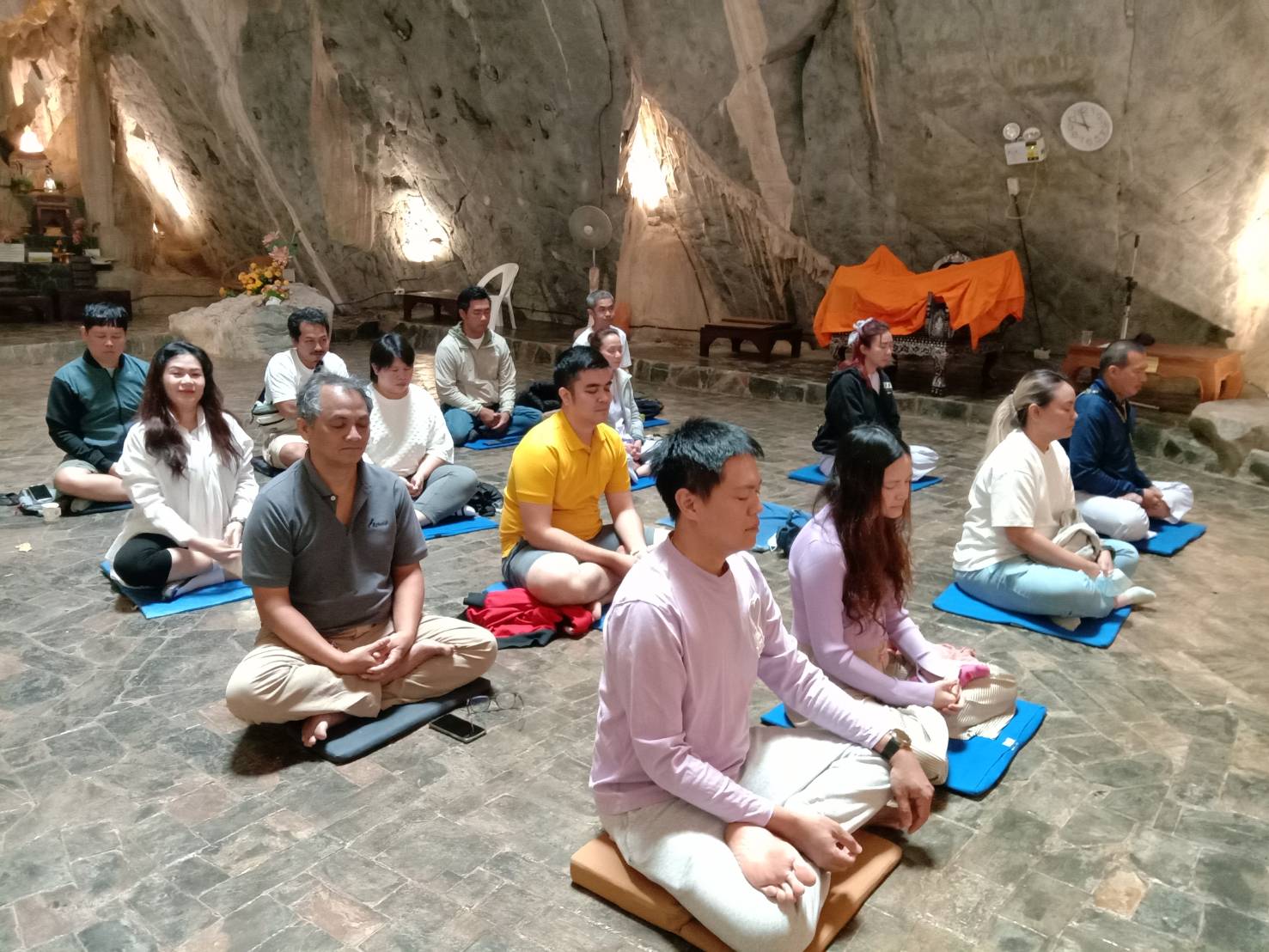 กลุ่มผู้ปฏิบัติธรรมนั่งสมาธิพร้อมกันในศาลาถ้ำ